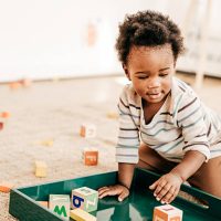Toddler putting together all toy blocks on the special green trayNominated for S+